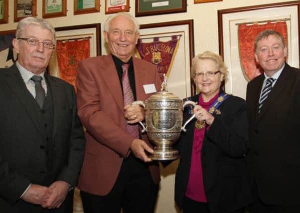 The Deputy Mayor of Lisburn City Council, Councillor Margaret Tolerton, holds the Gibson Cup with former Distillery goalkeeper Jack Kennedy. The Whites won the trophy in the 1962-63 season. Also attending the 50th anniversary event were Jim Greer(left), chairman of Lisburn Distillery Football Club and Alderman Paul Porter (right) from Lisburn City Council. Image copyright David Hunter. Lisburn City Council and the Ulster Star are free to use in connection with reporting the event.