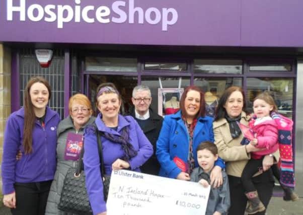 Una Crudden with her family and twin sister presenting a cheque for £10,000 to help build a new hospice