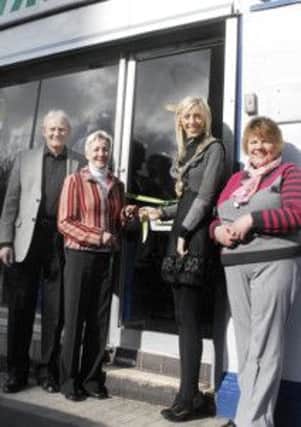 Mayor of Craigavon, Councillor Carla Lockhart pulls the ribbon to officially open the newly refurbished Samaritans Charity shop in Church place, Lurgan. Also included are Craigavon samaritans officers from left, Drew Boyd, chairman, May Crealey, director, and Maureen Gallagher, shop manager. INLM14-216