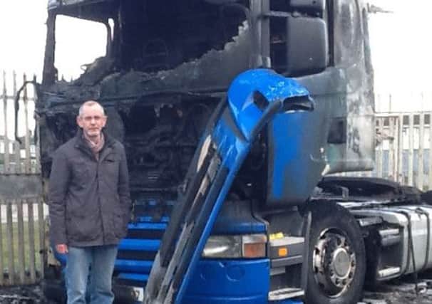 Sinn Fein Cllr Noel McGeown beside a burnt lorry