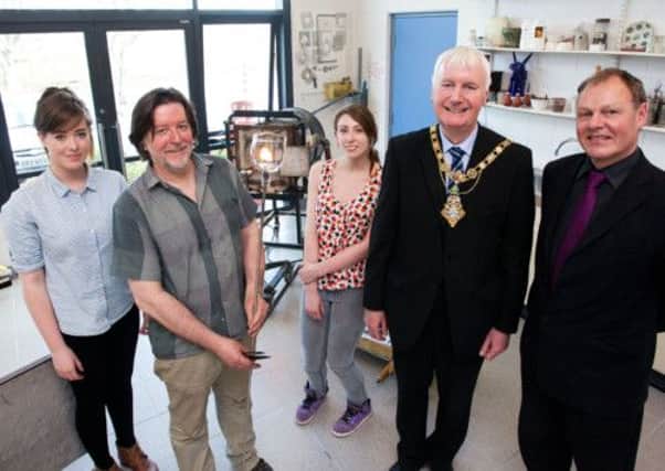 Glass blower, Scott Benefield, with Councillor Sam Cole, Mayor of Coleraine, Flowerfield Manager, Malcolm Murchieson and Art Students, Sarah and Ashleigh during a visit to the glass blowing facilities at Flowerfield on Thursday. CR17-411PL