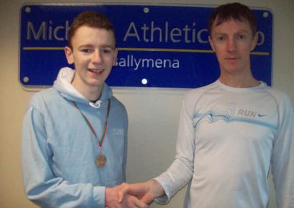 Conor McQuillan is congratulated by his Fit N Running coach Gregory Walsh on his two recent personal best performances.