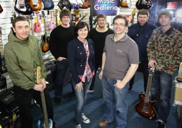 Angela Watson and Colin Johnston (centre), from Music Galleria on Antrim Street, with members of Lisburn band Pretty Cartel who have released their latest EP 'Tales of the Working Class'. The EP is now available at Music Galleria. US1317-506cd