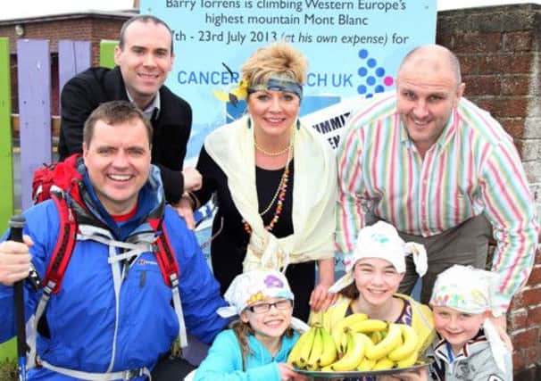 Barry Torrens, who is climbing Mont Blanc in July to raise funds for Cancer Research UK, is pictured with his children Jenny, Anna and William along with Mark McMahon from Cancer Research UK, Karen Maguire, teacher, and Carwyn Guy, principal, during a fundraising bananas and bandanas day at Portrush Primary School on Friday. CR16-410PL