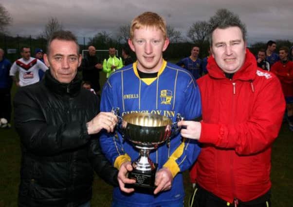 Melvyn and Ryan McAuley present the George McAuley cup to Carnlough Swifts captain Michael Abram after his team beat Abbeyview. INBT19-228AC