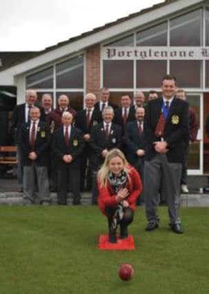 Karen Pearson delivers the first bowl to open the green as President Mark Pearson and club members look on.