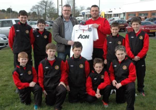 Joe Devlin donates a Sir Alex Ferguson signed Man Utd shirt to Carniny Youth U12 manager David Parker for raffle at their forthcoming Night at the Races