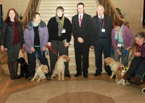 Ballymena Councillor and DUP MLA Paul Frew pictured at Stormont with members of the Charity, Assistance Dogs Northern Ireland (ADNI) who had sought his help in trying to clear up some confusion around whether assistance dogs need to be licensed when being trained by the charity .