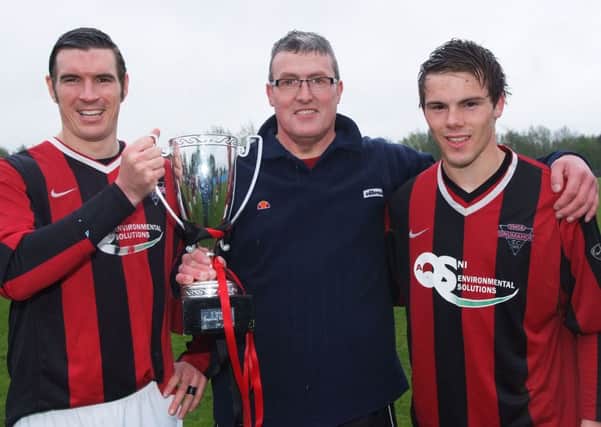 Drumahoe manager Terry Martin holds the O'Bryan Cup aloft at Wilton Park on Saturday. Included are Ryan Devine, left, club captain, and Andrew Wilson. INLS2113-152KM