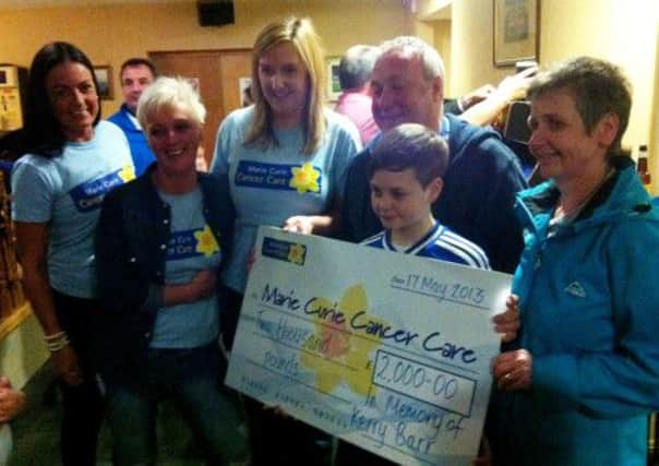 Representatives of the original Ballymena Allstars football team and the Barr family present a cheque for £2,000 to Anne McRoberts, of Marie Curie Cancer Care, proceeds of last week's charity football match.