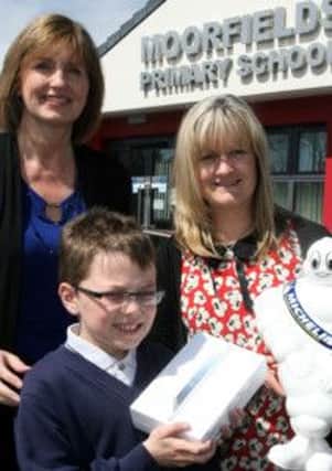 Ryan Penny, from Moorfield PS, winner of the name the Michelin windmills competition is pictured receiving his prize of a mini iPad from Sharon Mullan (communications manager) and Kathy Simpson (personnel manager). Ryan named the windmills "Mich" and "Ellen". INBT21-201AC