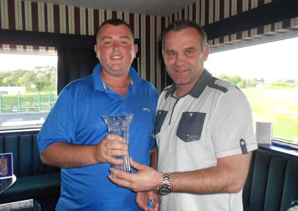 Gareth McCullough, overall winner at the Ballymena United golf day, receives his prize from manager Glenn Ferguson.
