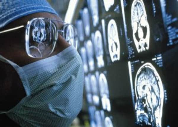 An oncologist inspects brain scan images.