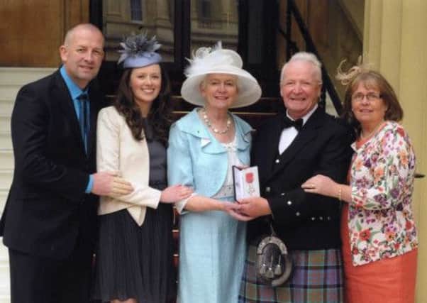Robert Alexander, pictured outside Buckingham Palace after receiving his MBE, with wife Kathleen, son Robin, daughter Catherine Lynas and grand-daughter Jennifer Lynas. . INLT 25-801-CON