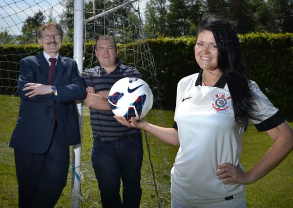 Brazil missionary worker and SC Corinthians fan Katherine Duncan, from Kells, with one of the footballs donated by Stuart Gordon from suppliers The Beautiful Game, who is seen along with Milk Cup chairman Victor Leonard.