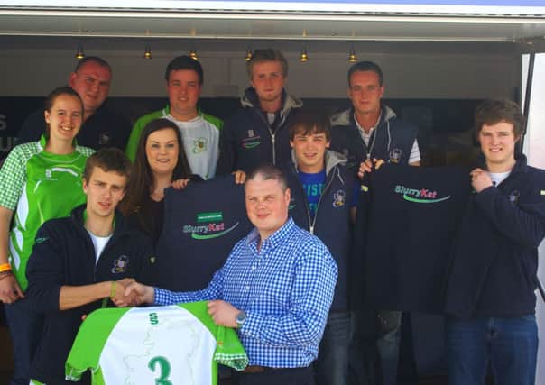 Garth Cairns from SlurryKat presents a jersey to students from Harper Adams.