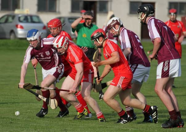 Conor McClorey and Tony Hegarty in a chase for possession.