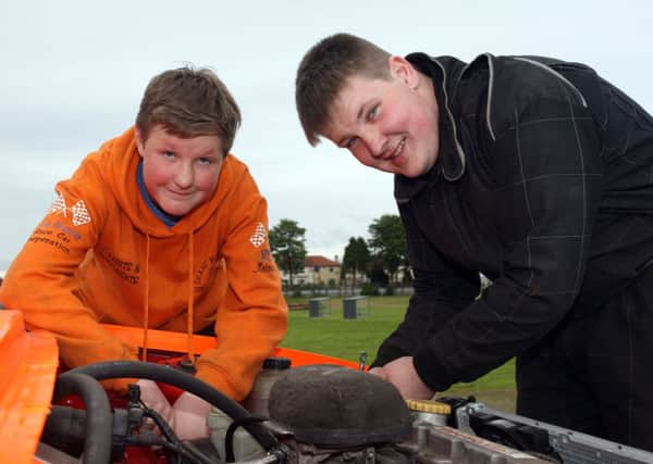 Shane and Derek McMillan make a few adjustments to their car at Ballymena Raceway. INBT26-238AC