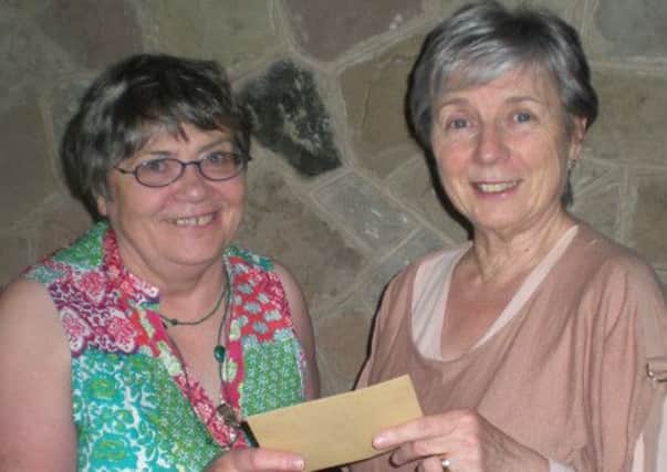 Newtownabbey Soroptimist president presents a cheque for £230 to Rita Allen, BIG project liason officer. INNT 26-611con