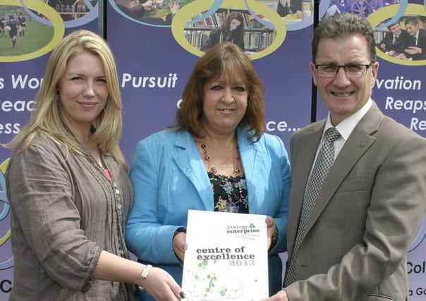 Mrs Laura Kerr from Young Enterprise presents Mr. Alistair Rowan, Principal at Sperrin Integrated College, Magherafeltand Mrs Joanne Martin Head of Business studies, with a Young Enterprise centre of excellence award for the College. INMM2613-240.