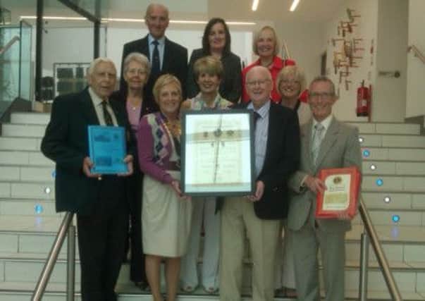 Ballymena Lions Club President Anne Henry presents the twinning document from the recent ceremony with their Gibraltar counterparts to Councillor Tommy Nicholl, for inclusion in the Braid Museum and Arts Centre. Included are members of Ballymena Lions Club.