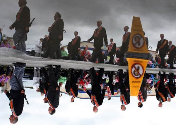 The reflection of the members of the Orange Order in Rossnowlagh at the weekend as thousands braved the elements for the only official Orange Parade in the south of Ireland which anually comes before the 12th of July celebrations of the 1690 Battle of the Boyne .Picture Brian Mc Daid