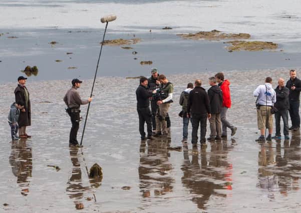 Sir Ben Kingsley (far left) films a scene for Our Robot Overlords on the beach in Carrickfergus last week.  INCT 27-405-RM