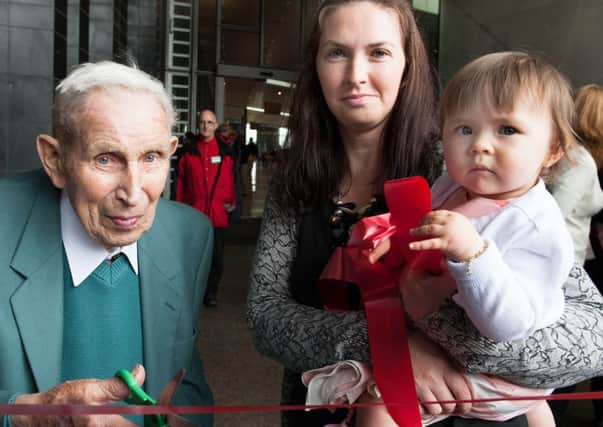 Oldest visitor Alan McKay age 97 former flag boy on the trams at the Giants Causeway with youngest visitor Tegan Carey age 1 with mum Sharon officially opening the Visitors Centre at the Giants Causeway.