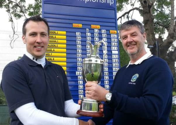 Jonny Patterson is presented with the Club Champions Trophy by Gents Captain Glenn Willis after the club championship playoff at Rockmount Golf Club.