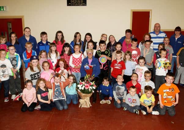Joan McClean, who retired from Harryville Youth Club after 10 years, is pictured with children and leaders who presented her with gifts at a special evening in the club. INBT27-238AC