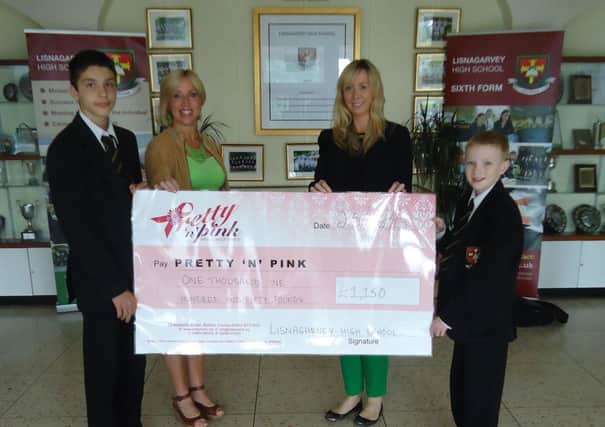 Claire Sands (left) presents the cheque for £1150 to Noeleen McErlane (right) from Pretty 'n' Pink breast cancer charity.