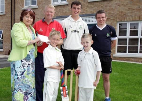Marie Fergusion, from Braidwater property developers, presents a cheque to Graham Kenny, president of Derriaghy Cricket Club, to help with the refurbishment of the club-house. Included are Derriaghy cricketers Curtis Moorehead and Scott Hughes and under-11 team members Ben Kenny and Ben White. US1328-532cd