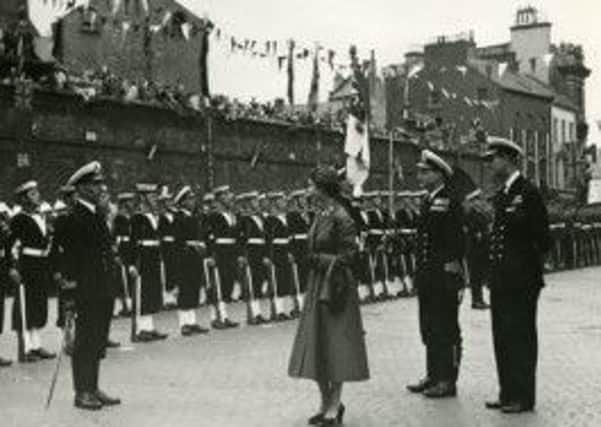 Elizabeth II of the United Kingdom of Great Britain and Northern Ireland inspecting naval troops in Shipquay Place.
