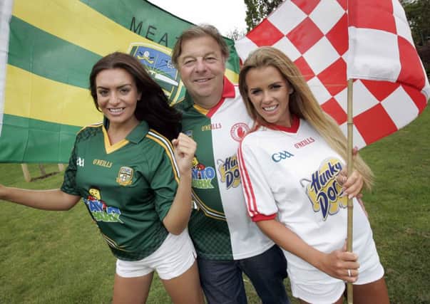 NO REPRO FEE 25/7/2013 Models Lisa Nolan (Meath) and Holly Keating (Tyrone) with Largo Foods C.E.O. and Tayto Park Creator Raymond Coyle wearing his split Meath/Tyrone jersey, pictured at Tayto Park to announce that, as sponsors of both teams, Largo Foods will had out 20,000 bags of Tayto and Hunky Dory Crisps to Meath and Tyrone supporters before the All Ireland Senior Championship series round 4 qualifier in Croke Park this Saturday 27th July. Photo: Mark Stedman/Photocall Ireland