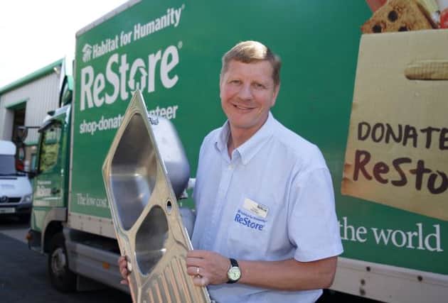 Niall McConkey unloads items for the kitchen department at ReStore.