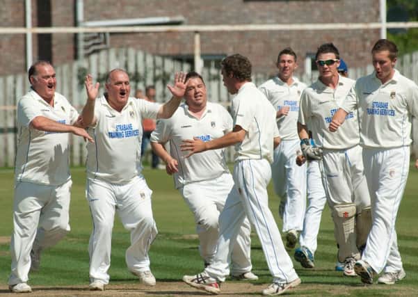Donemana bowler Andrew McBrine is mobbed by his team-mates after he had claimed the wicket of Brigade opener Mattie Moran.