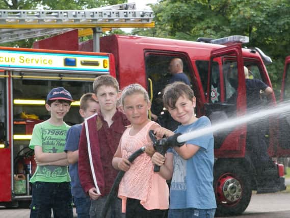 Matthew Mullen and Charlie Kidd try some fire fighting at the Glengomley summer scheme. INNT 31-409-RM