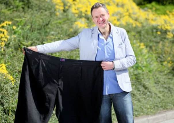 Thomas McIntyre with a pair of trousers that he used to wear before his weight loss. INLT 31-606-CON