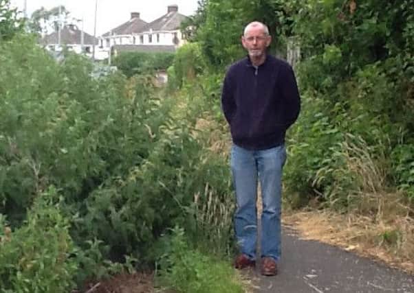 Sinn Fein Cllr Noel McGeown beside an overgrown walkway at Kilwilkee INLM31 016