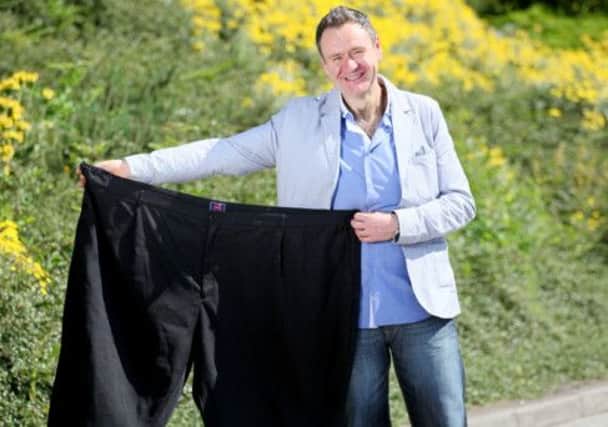 Thomas McIntyre with a pair of trousers that he used to wear before his weight loss. INLT 31-606-CON