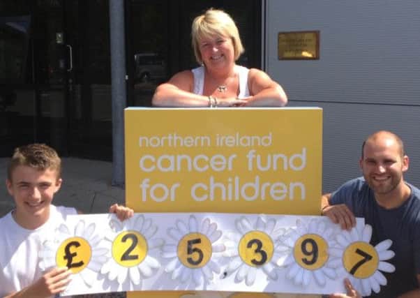 Gaye Kerr with son Adam and Phil Anderson of the NI Cancer Fund for Children