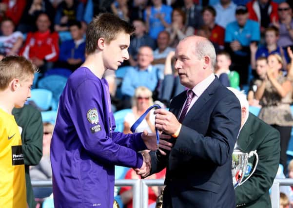 Co. Antrim goalkeeper Chris Simpson, from Ballymena, receives his runners-up medal after his sides penalty defeat by Everton. INBT32-251AC