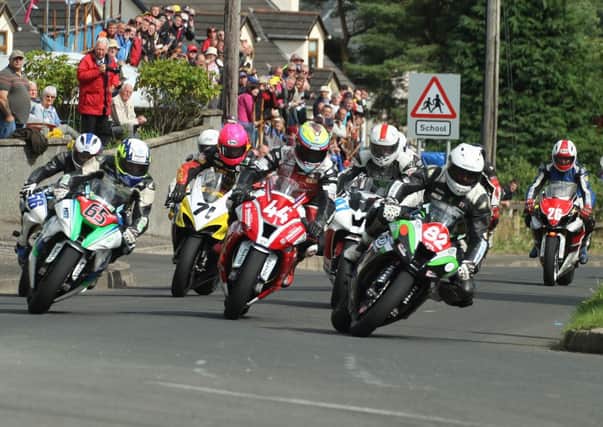 Derek Sheils leads Jamie Hamilton and Michael Sweeney on the first lap of the Open race during Saturday's Mid-Antrim 150 road races, as a bumper crowd at Clough looks on. Picture Roy Adams. Don't miss pages 48-49 for Roy's comprehensive coverage of the meeting.