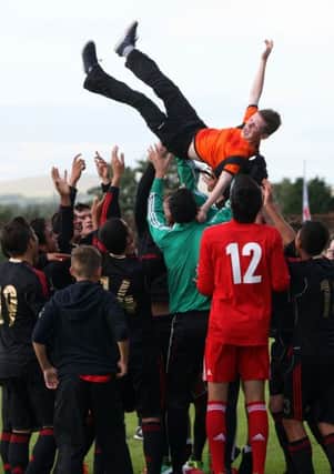 Brendan McDonell, from Ballymena, who was "adopted" by the Mexico team as their mascot gets lofted in the air by the team after their win over Northern Ireland. INBT32-266AC