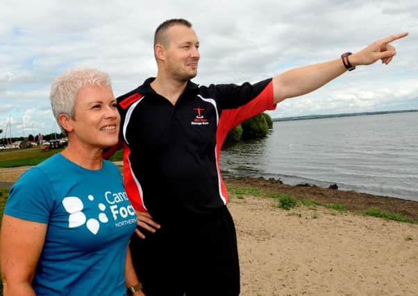 Lucas points out his Lough Neagh swimming route to Emma McCann, from Cancer Focus. INMM3213-255ar.