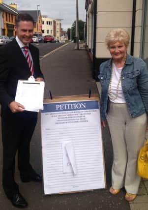 Cllr Paul Frew DUP MLA helping Pinewood campaigner Margaret Wallace get signatures on their petition.