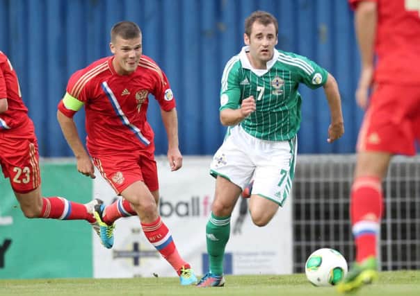 Northern Ireland's Niall McGinn skips away from Russia captain Igor Denisov, during their World Cup Qualifier, at Windsor Park.
