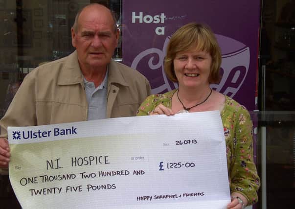 Terry Sloan hands over the proceeds of the fundraiser to a representative of the shop in Coleraine. INCR34-133s