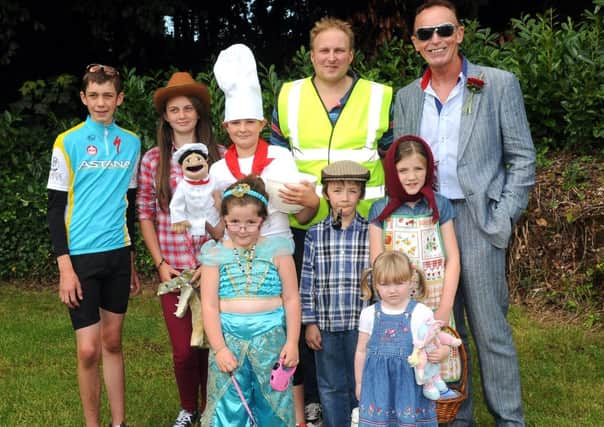 Magherafelt Council Good Relations Officer Sean Henry, who was the judge at the fancy dress at the Desertmartin Parish Garden Fete and Vintage Rally, pictured with some of the competitors and Trevor Kingston, one of the organisers of the annual event. INMM3413-157ar.