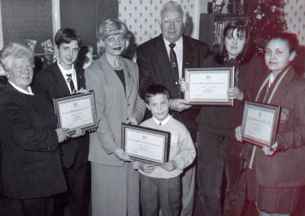 Elaine Way, a senior manager at the Foyle and Altnagelvin Trusts in 1997, pictured with Norman Campbell, presenting creativing writing certificates to local school children.